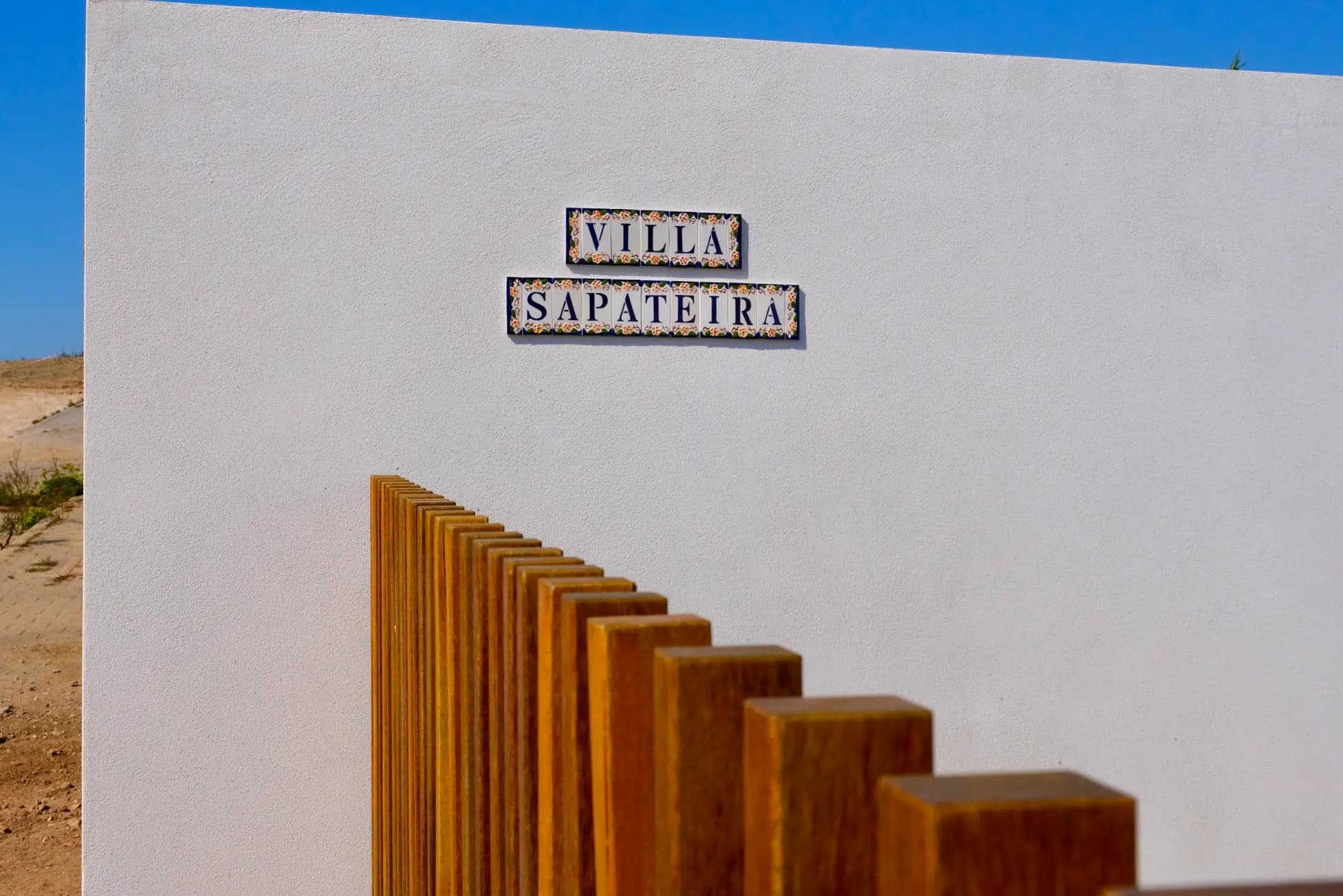 Portail en bois avec la plaque Villa Sapateira